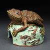 Clay frog on a turquoise rock.