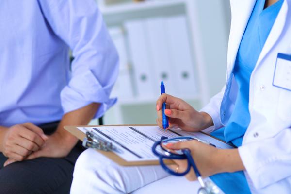 woman with clipboard and stethoscope talking with patient