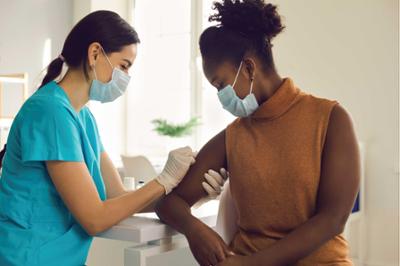 nurse giving shot to patient for immunization