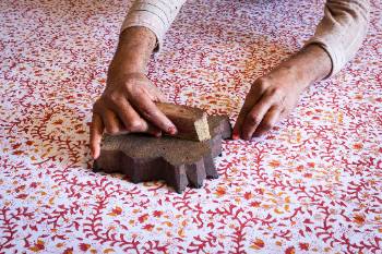 using large block stamp on fabric to create red and yellow flower pattern