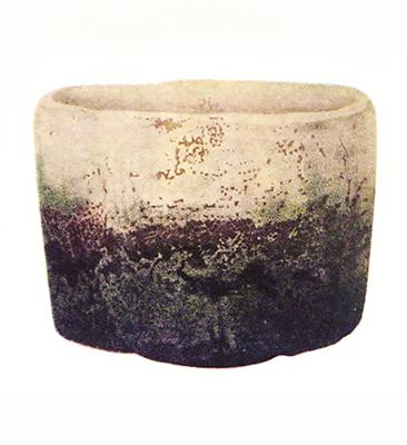 A potter turns a small vase on a potter's wheel