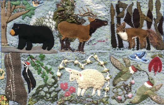 A detailed image of a quilt having wool sewn in shapes of animals into the fabric. The animals include a bear, sheep, bird, and other local Appalachain creatures.