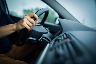 hands on steering wheel can see dark dashboard