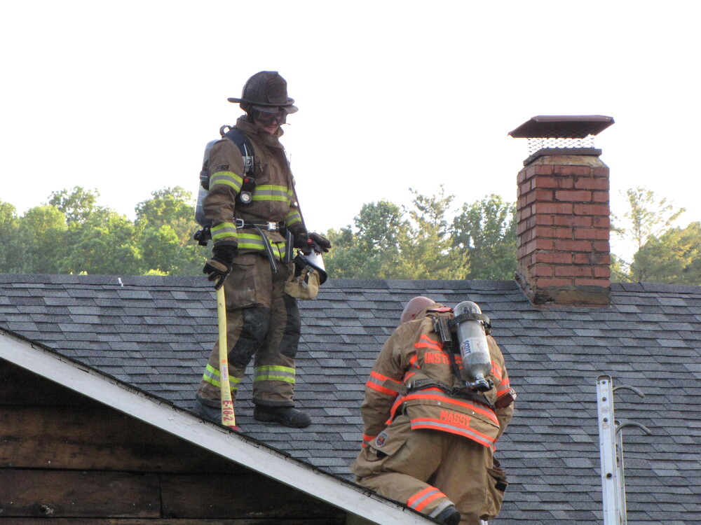 Two firemen on a roof