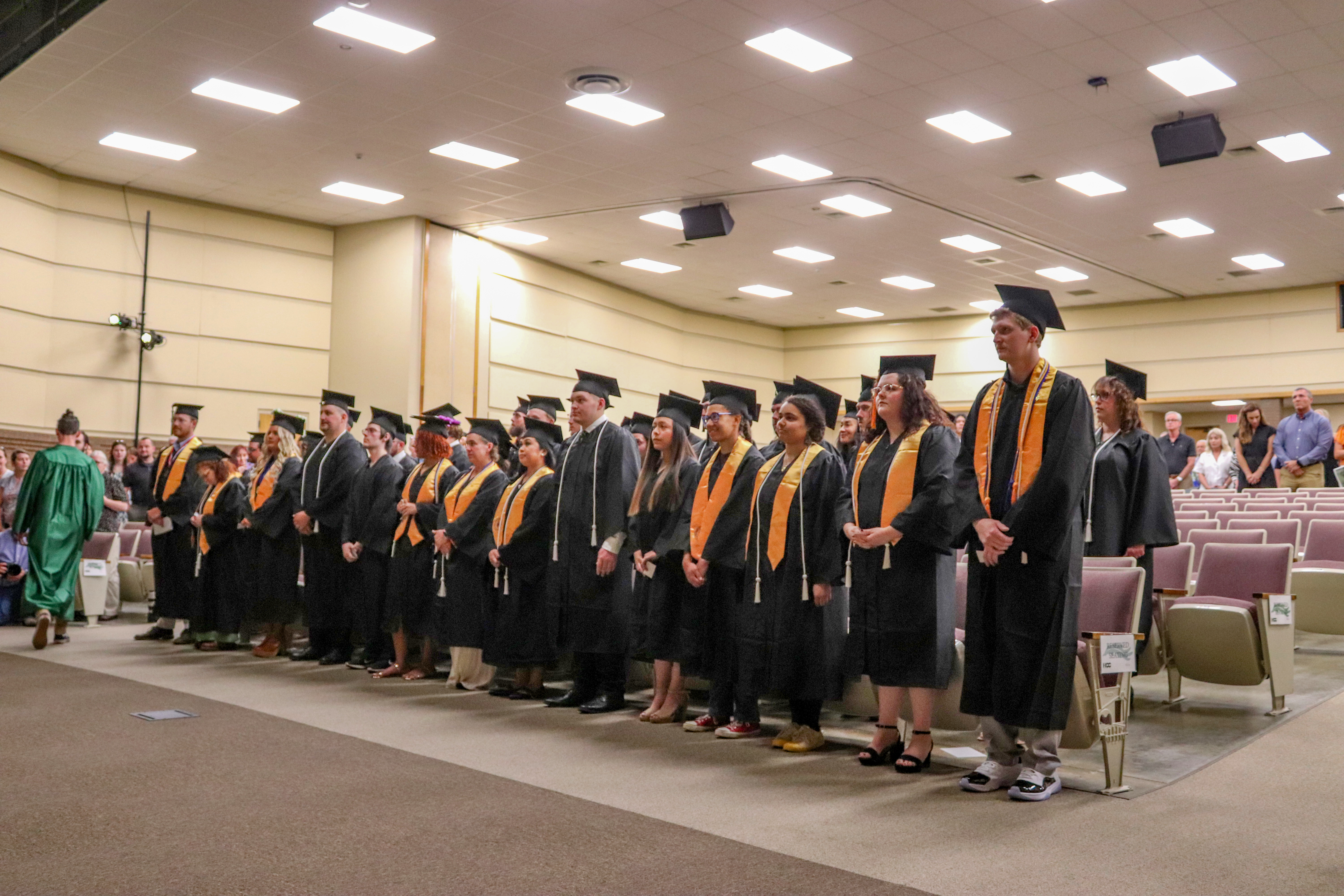 students at graduation standing with their cap and gowns on