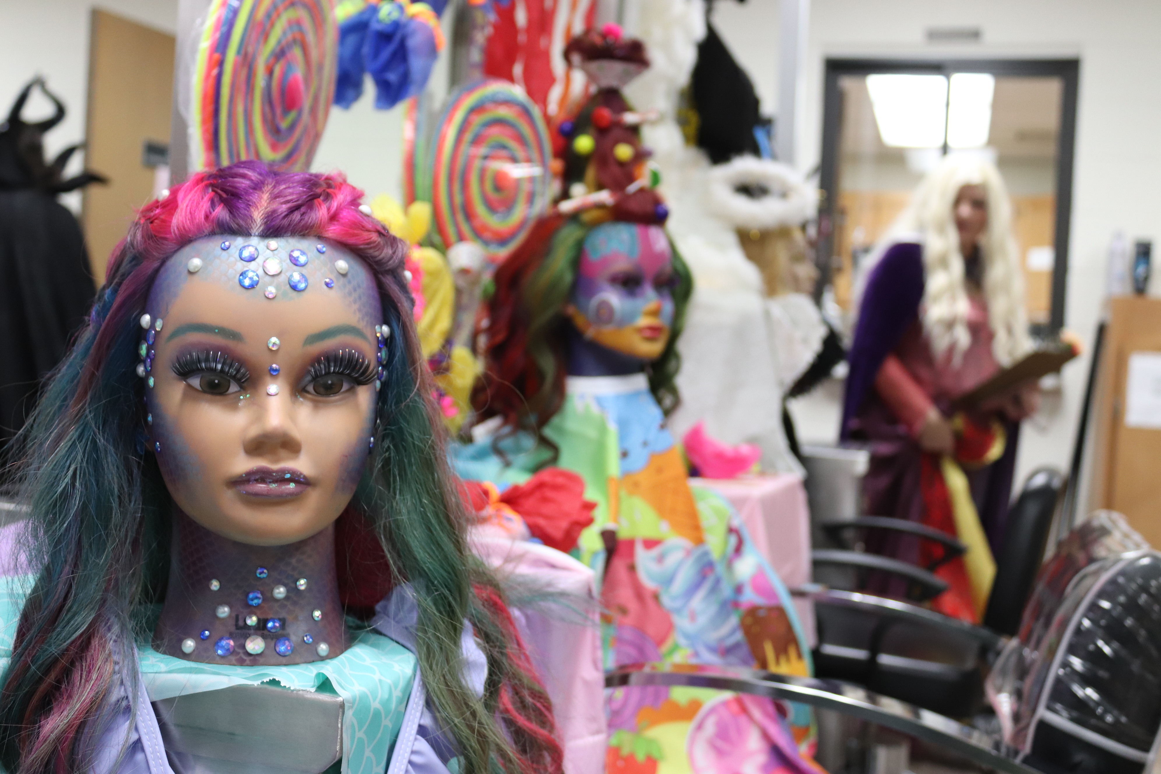 decorated manikin head in row of other displays