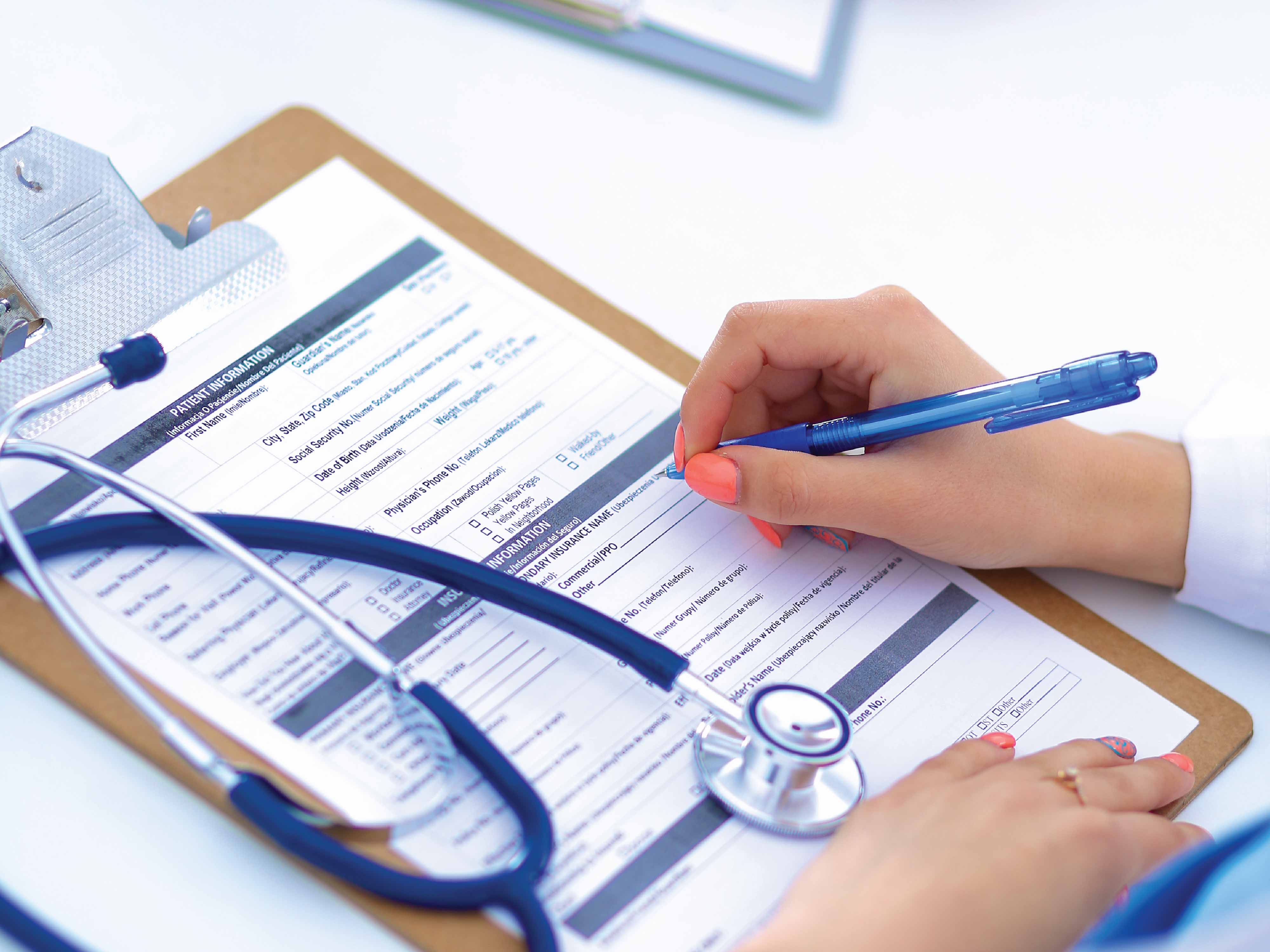 clipboard with medical form and woman writing with stethascope