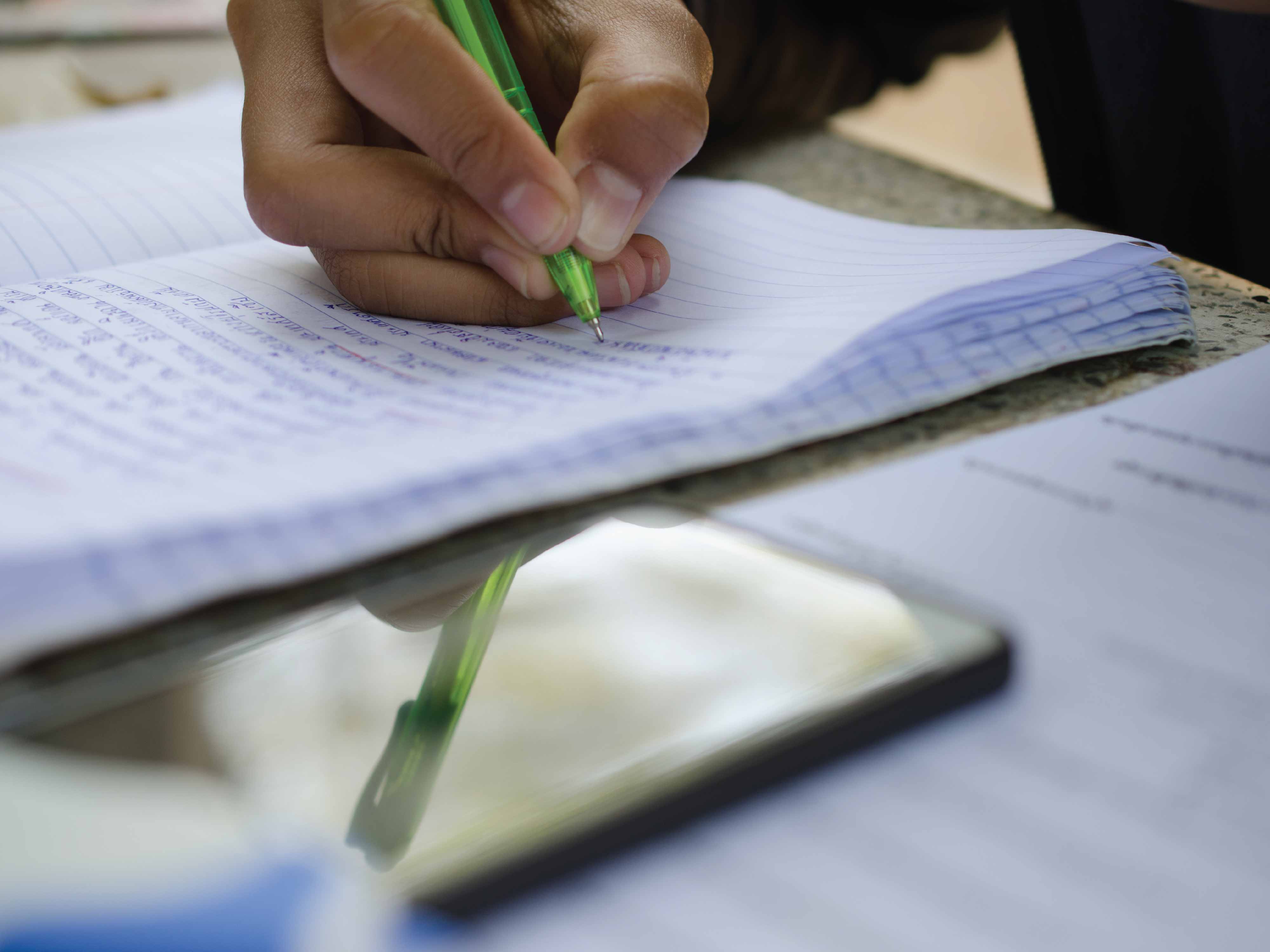 student writing in notebook