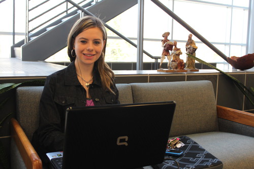 Girl sitting on a couch with a laptop