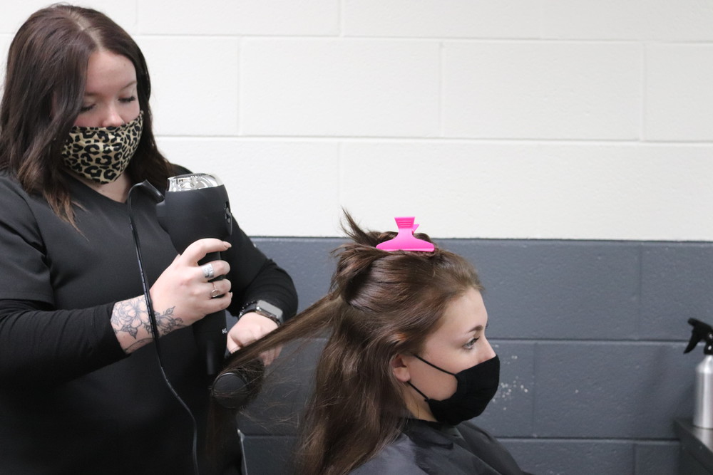 student cutting hair of a female client