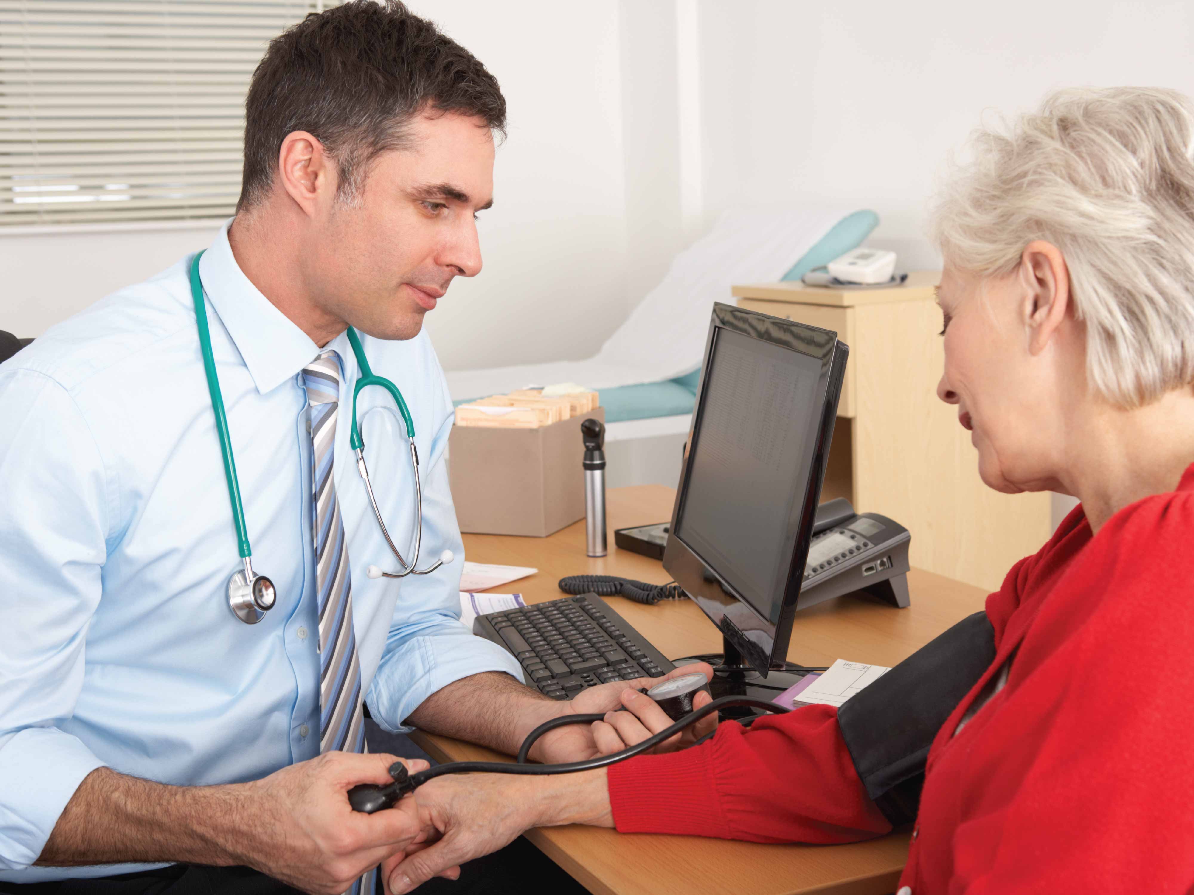 guy taking woman's blood pressure